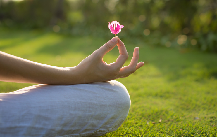 A woman meditating outdoor. Yoga lotus pose.